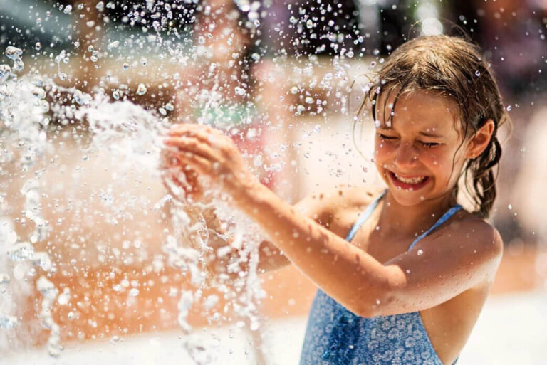 Girl playing with the water in the pool